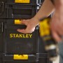 Cassetta porta attrezzi nera Stanley con dettagli gialli e mano, parte di un set di cassette.