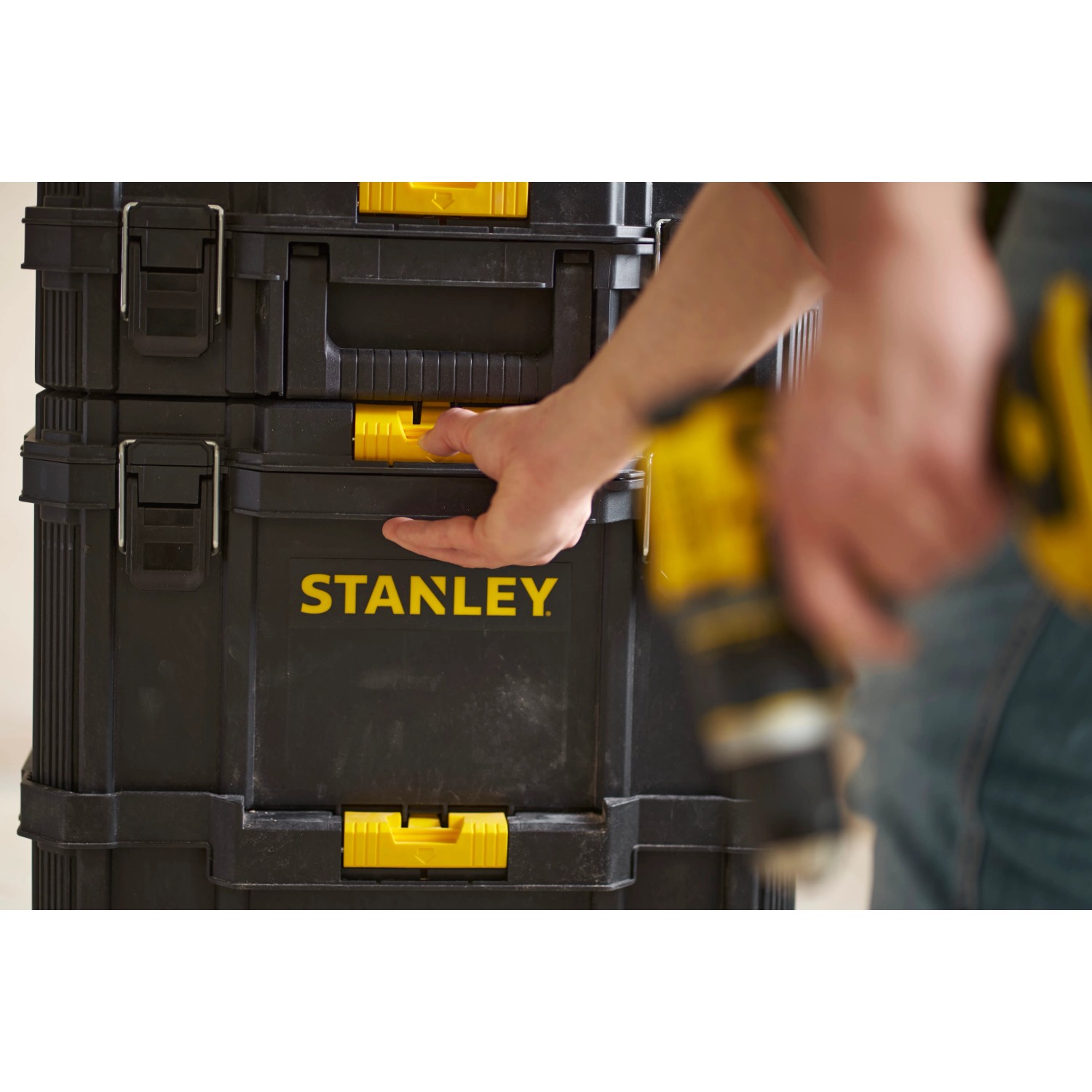 Cassetta porta attrezzi nera Stanley con dettagli gialli e mano, parte di un set di cassette.
