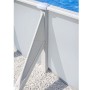 Piscina con parete in acciaio bianca, superficie ondulata e palo di supporto. Acqua blu, su ghiaia.