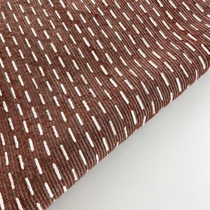 Tappeto da bagno t.b.t. marrone con cuciture decorative bianche.