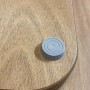 Dettaglio di un accessorio doccia t.b.t. grigio su legno.