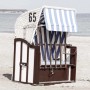 Sedia a sdraio Quadri con strisce blu e bianche e il numero 65 sulla spiaggia.