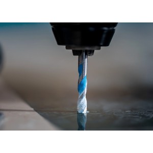 Punta da trapano Bosch Expert Multi Construction CYL-9 in uso, punta universale con spirali blu.