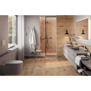 Bagno con piastrelle per pavimenti t.b.t. color legno marrone chiaro e doccia con piastrelle a parete abbinate.