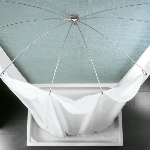 Doccia con tenda e accessori. Piastrelle chiare sullo sfondo.
