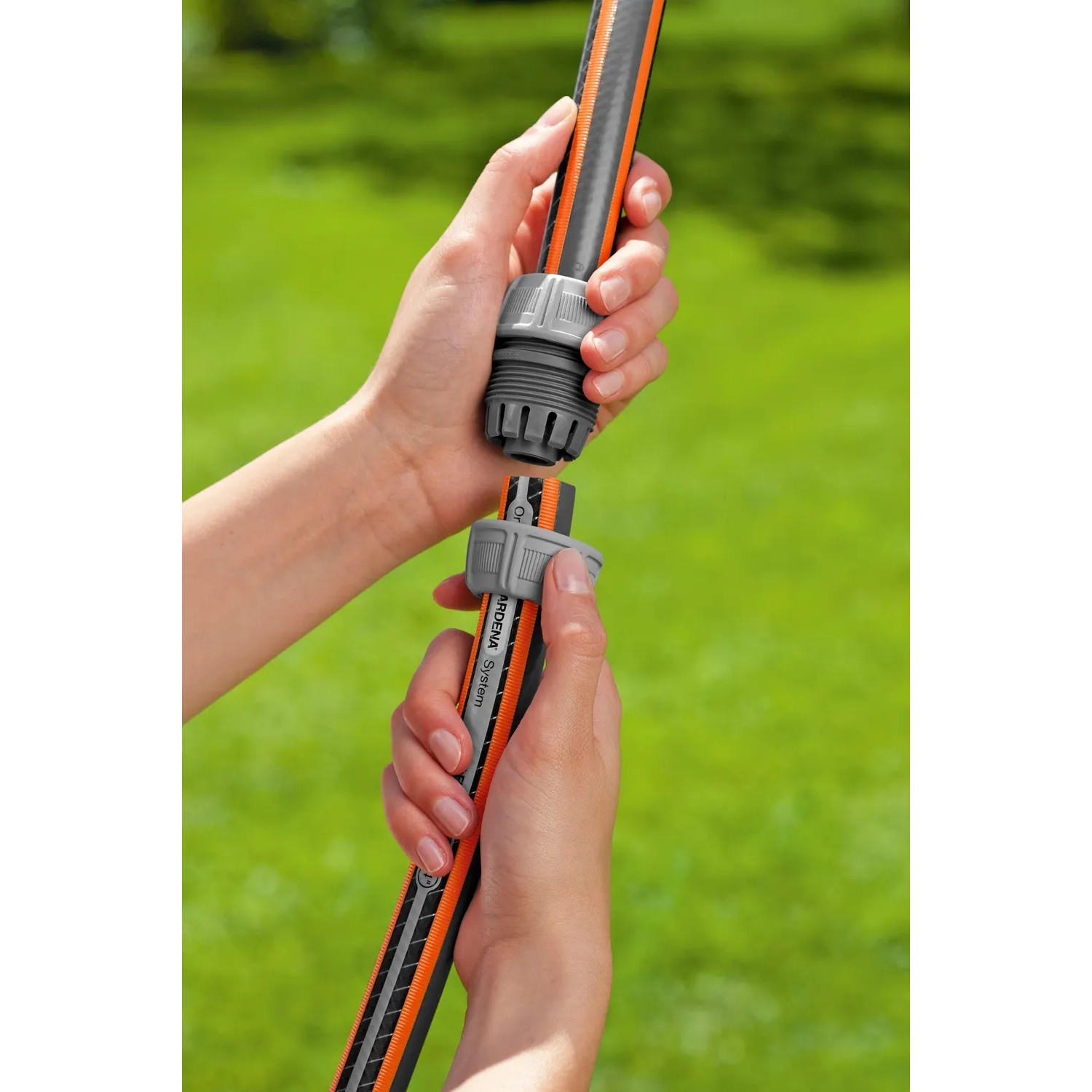 Raccordo riparatore Gardena 19 mm (3/4) per tubo da giardino in fase di collegamento.