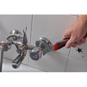 Chiave meccanica t.b.t. in uso su un rubinetto del bagno.