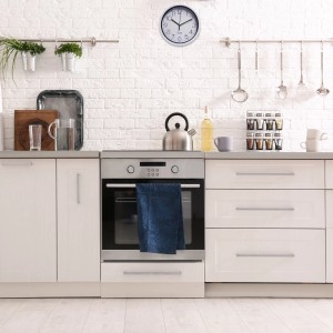 Orologio da parete in cucina con mobili bianchi. Orologio decorativo per la casa.