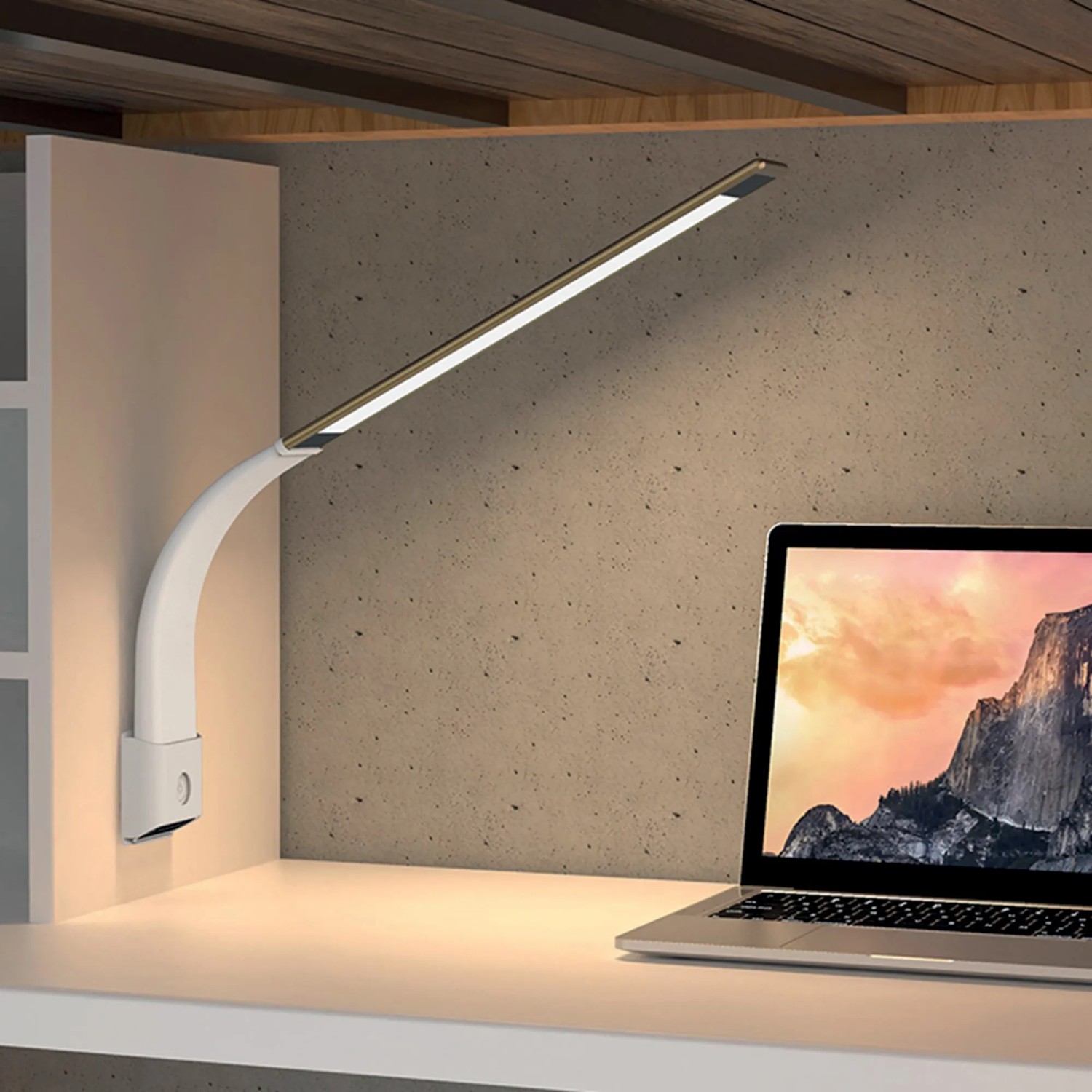 Moderna lampada da scrivania a LED bianca accanto al laptop sulla scrivania.