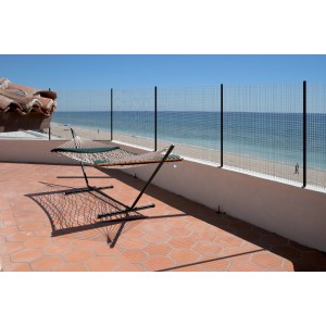 Recinzione metallica su terrazza con vista mare. Rete metallica come frangivento o privacy.