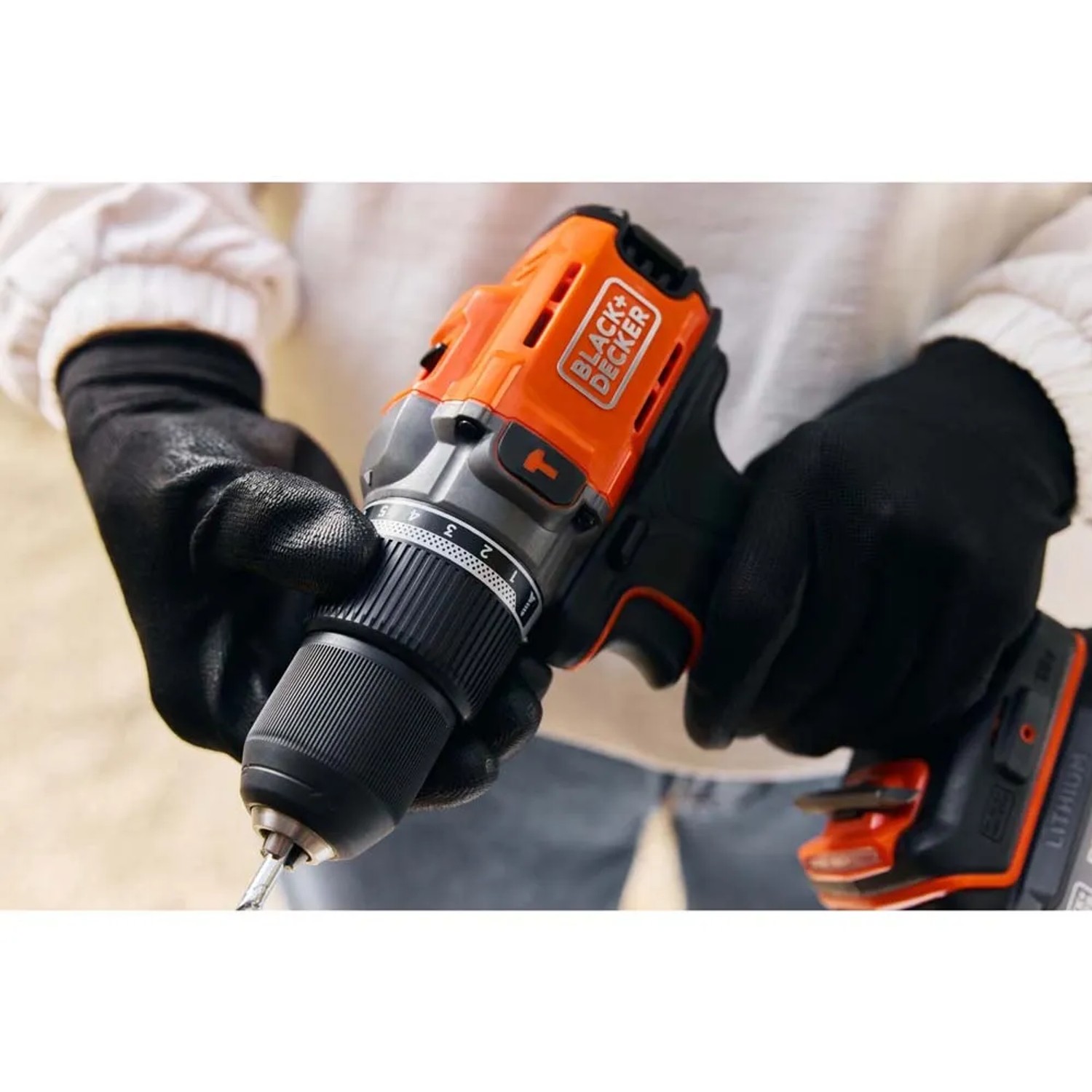 Avvitatore a batteria Black+Decker in azione, arancione e nero.