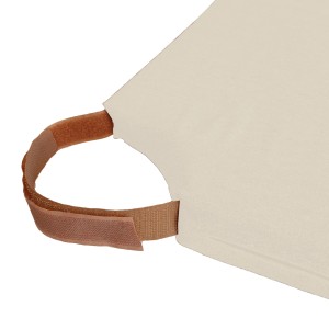 Dettaglio di un cuscino beige con maniglia e chiusura a velcro.