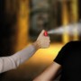 Donna si difende con spray al peperoncino da un aggressore. Autodifesa con maschera protettiva.