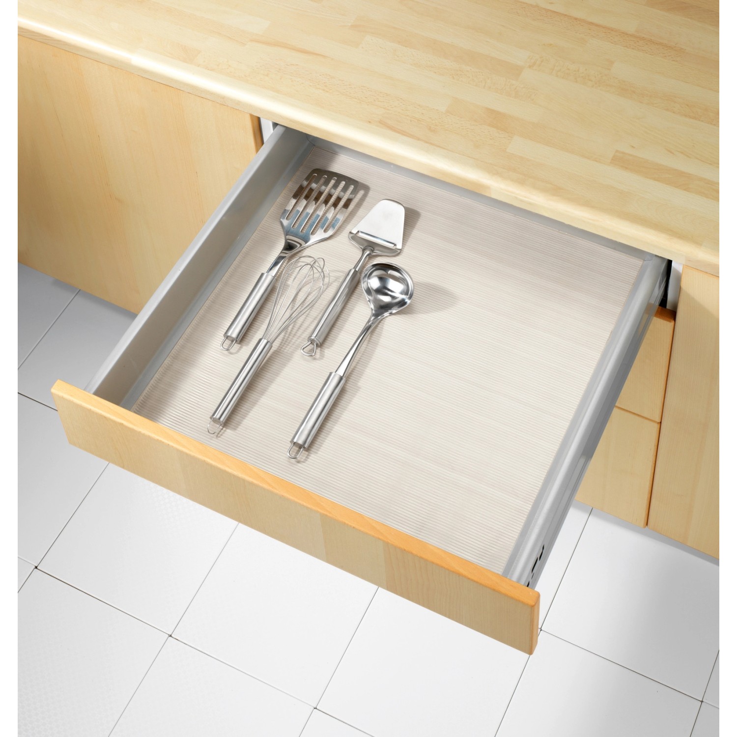 Tappetino antiscivolo trasparente Wenko (150x50 cm) in un cassetto con utensili da cucina.