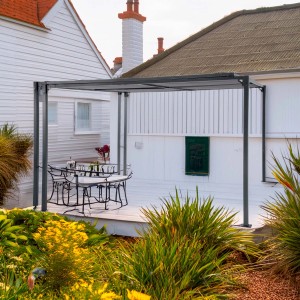 Gazebo t.b.t. grigio moderno con tavolo e sedie su un patio.