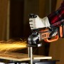 Smerigliatrice angolare a batteria Black+Decker BCG720M1 in uso, molatura con scintille.