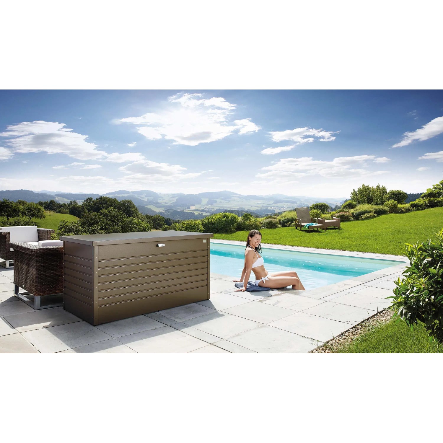 Biohort FreizeitBox 160 in bronzo metallizzato accanto a piscina e mobili da giardino.