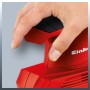 Levigatrice orbitale Einhell TC-OS 1520 in uso, levigatrice rossa con mano sull'interruttore.