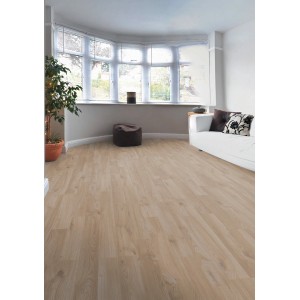 Pavimento laminato chiaro t.b.t. in soggiorno con divano e finestra.