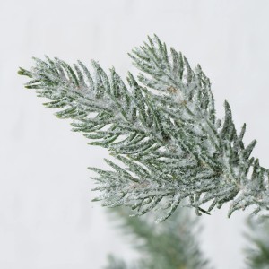 Dettaglio di un ramo innevato di un albero di Natale artificiale.