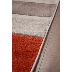 Dettaglio di un tappeto moderno a strisce in arancione, grigio e beige.