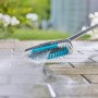 Gardena Cleansystem Spazzola Hard in azione: pulizia di pavimentazione in pietra con acqua.