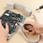 Set di meccanica di precisione in uso: Persona che ripara un telefono con pinze e cacciavite.