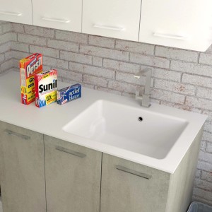 Mobile lavabo con lavabo bianco e rubinetto. Detersivi sullo scaffale.