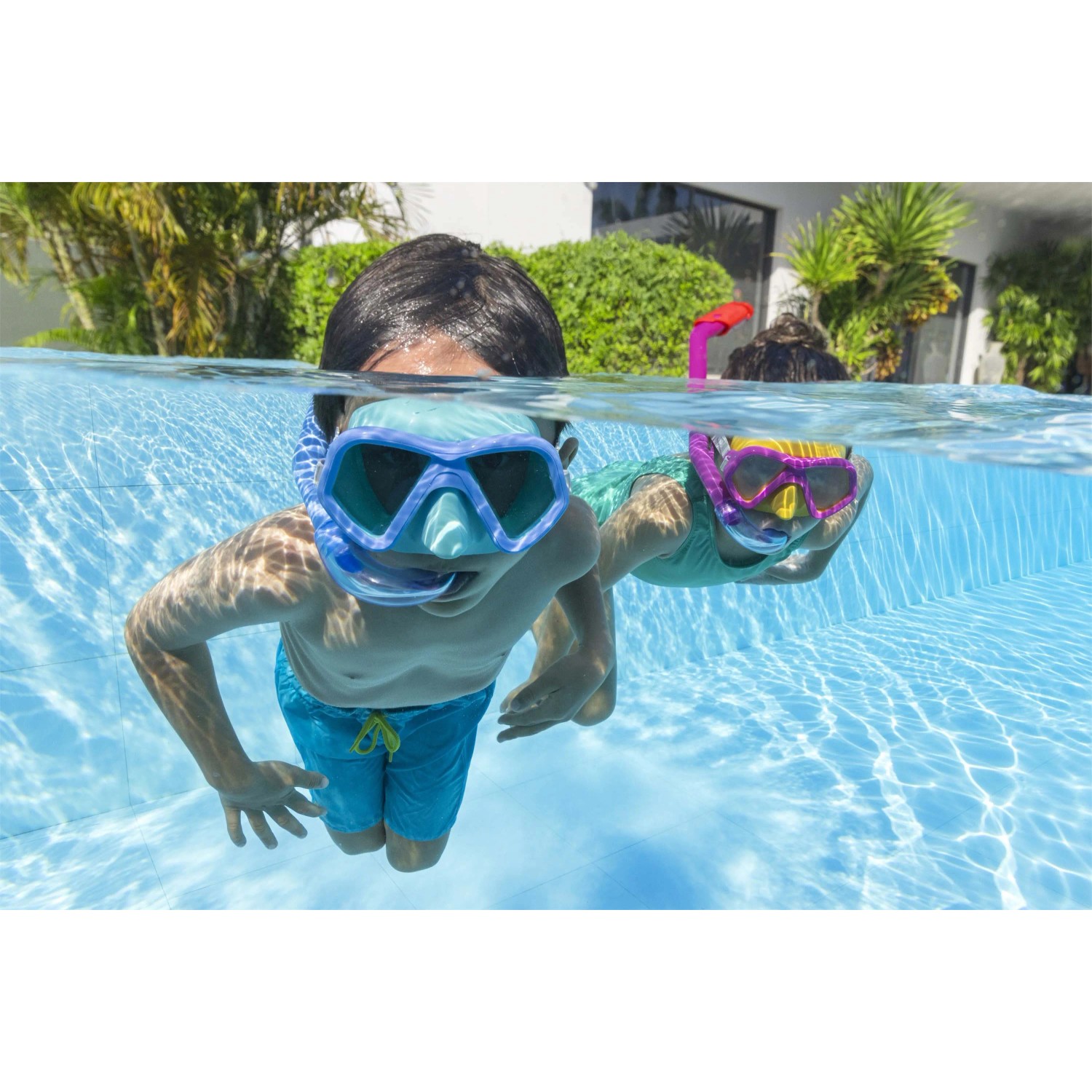 Bambini con maschere da sub e boccagli in piscina. Divertimento in acqua con accessori per immersioni OBI.