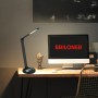 Lampada da scrivania a LED Brilo Cuma nera con ricarica induttiva su una scrivania.