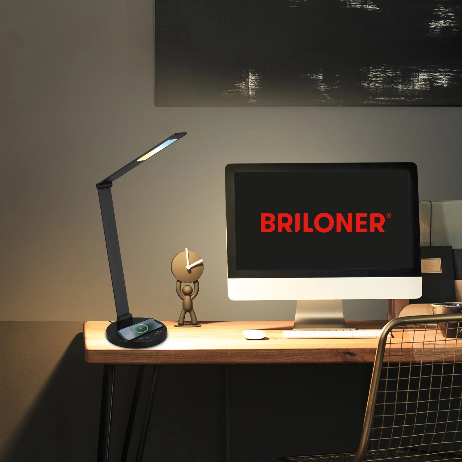 Lampada da scrivania a LED Brilo Cuma nera con ricarica induttiva su una scrivania.