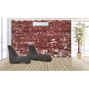 Due chaise longue t.b.t. grigie su un pavimento vinilico chiaro davanti a un muro di mattoni.