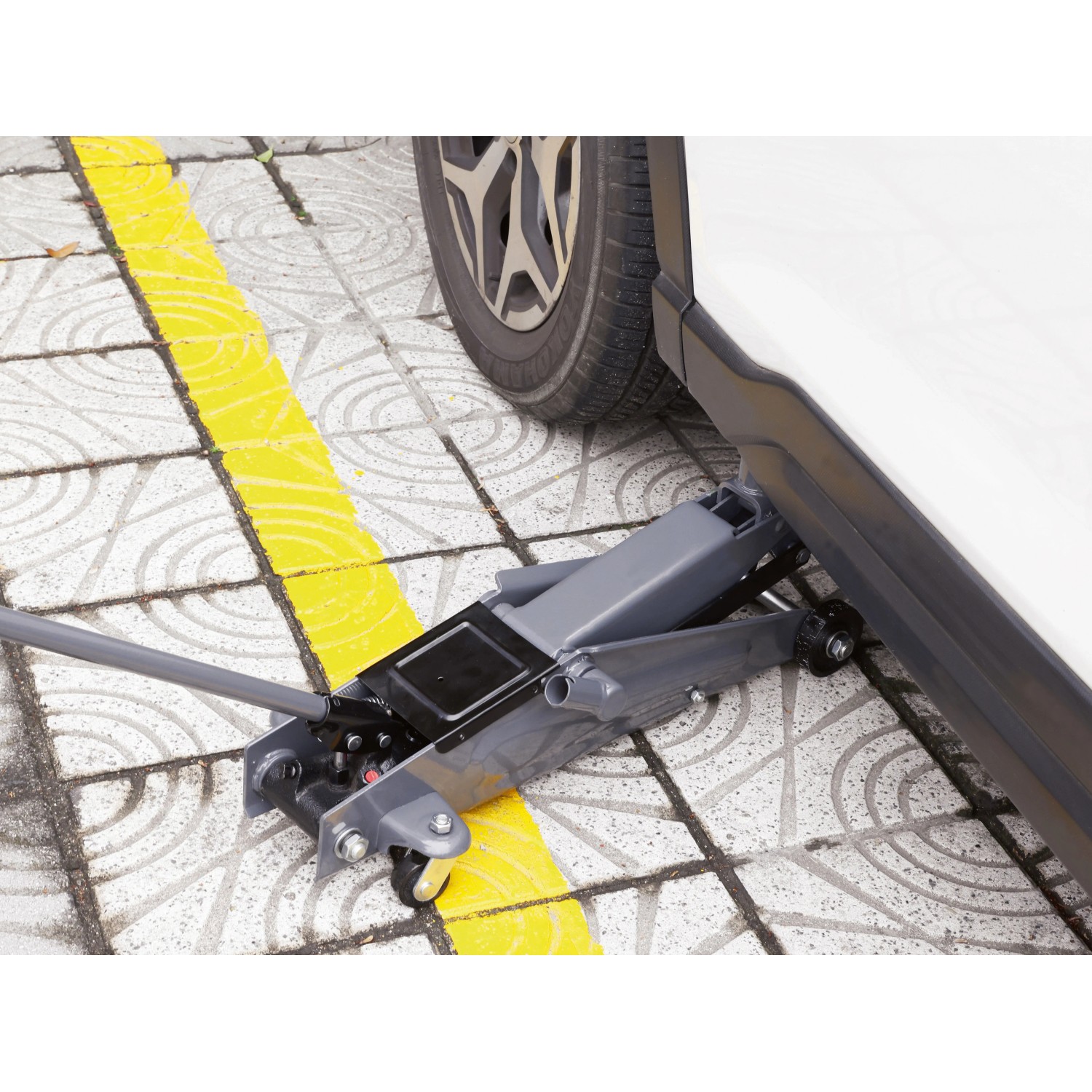 Cric a carrello grigio RWH-2500 B 2,5 t sotto un'auto per riparazione e manutenzione.
