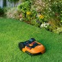 Robot rasaerba Worx Landroid M500 su erba davanti all'aiuola. Robot tagliaerba con batteria da 20 V.