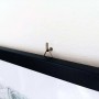 Primo piano di un appendiabiti Tasselli su una parete con un quadro incorniciato.