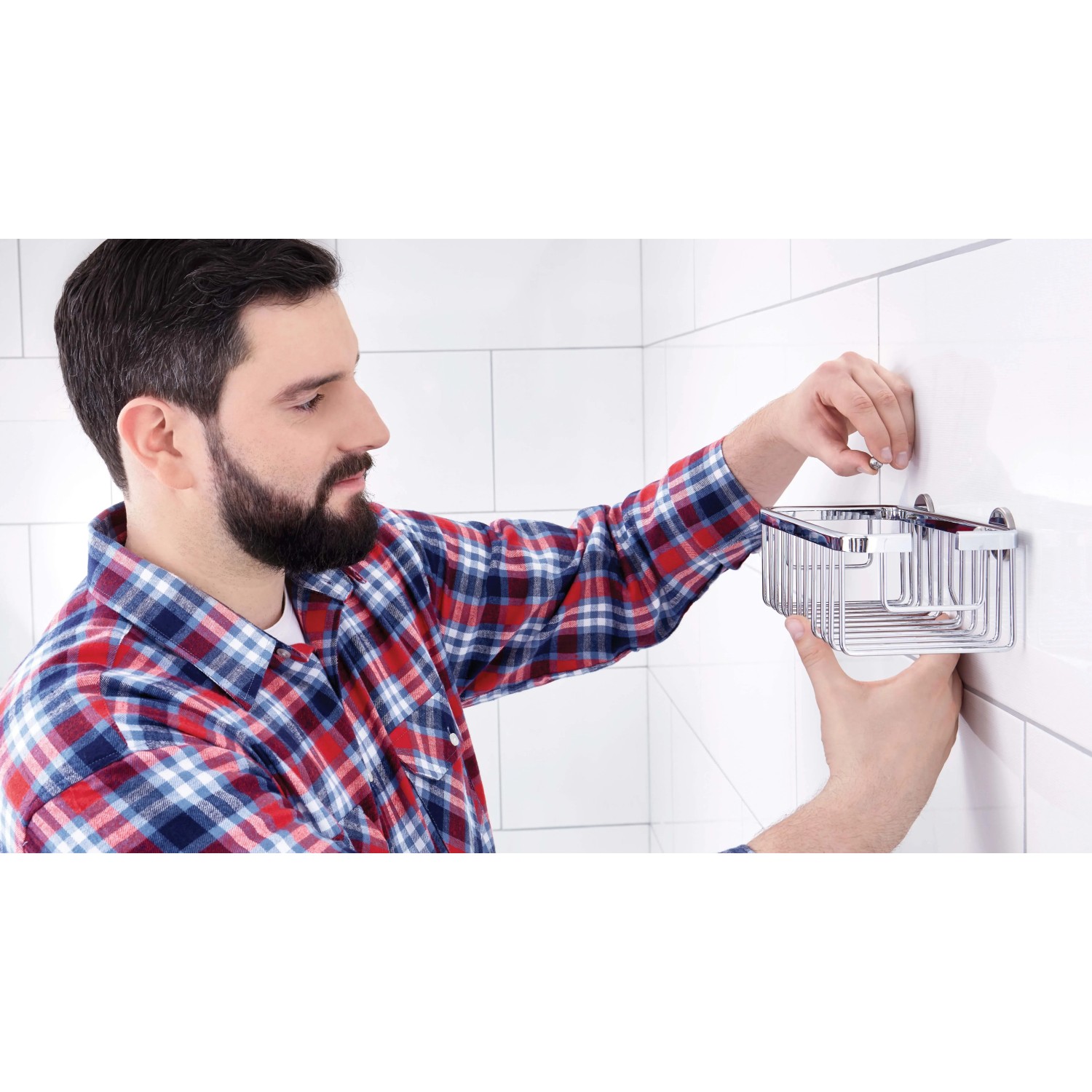 Uomo che monta il cestello doccia Tesa Aluxx (25 cm, cromato) sulla parete del bagno.