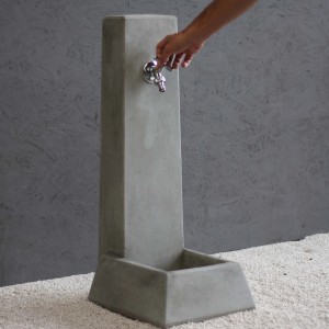 Fontana da giardino t.b.t. grigia con rubinetto in uso.