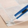 Cutter LUX Classic 100 mm blu taglia pavimento in PVC su superficie a motivo piastrelle.