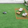 Robot rasaerba Dreame A2 su prato con mobili da giardino e perimetro.