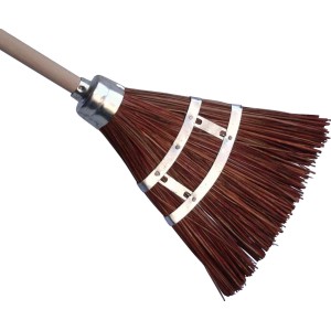 Scopa a mano in materiale naturale con manico in legno e fascia metallica, adatta per spazzare le foglie.