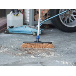 Testa di scopa professionale LUX in cocco da 40 cm che spazza lo sporco sul pavimento di cemento.