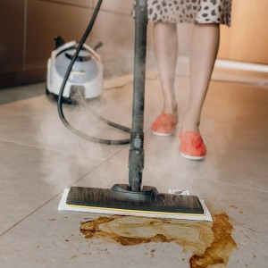 Pulitore a vapore Kärcher SC 5 EasyFix Iron Plug in uso su pavimento piastrellato con sporco.