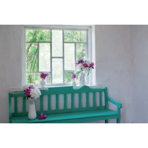 Scena decorativa con vasi di fiori su una panca turchese davanti a una finestra.