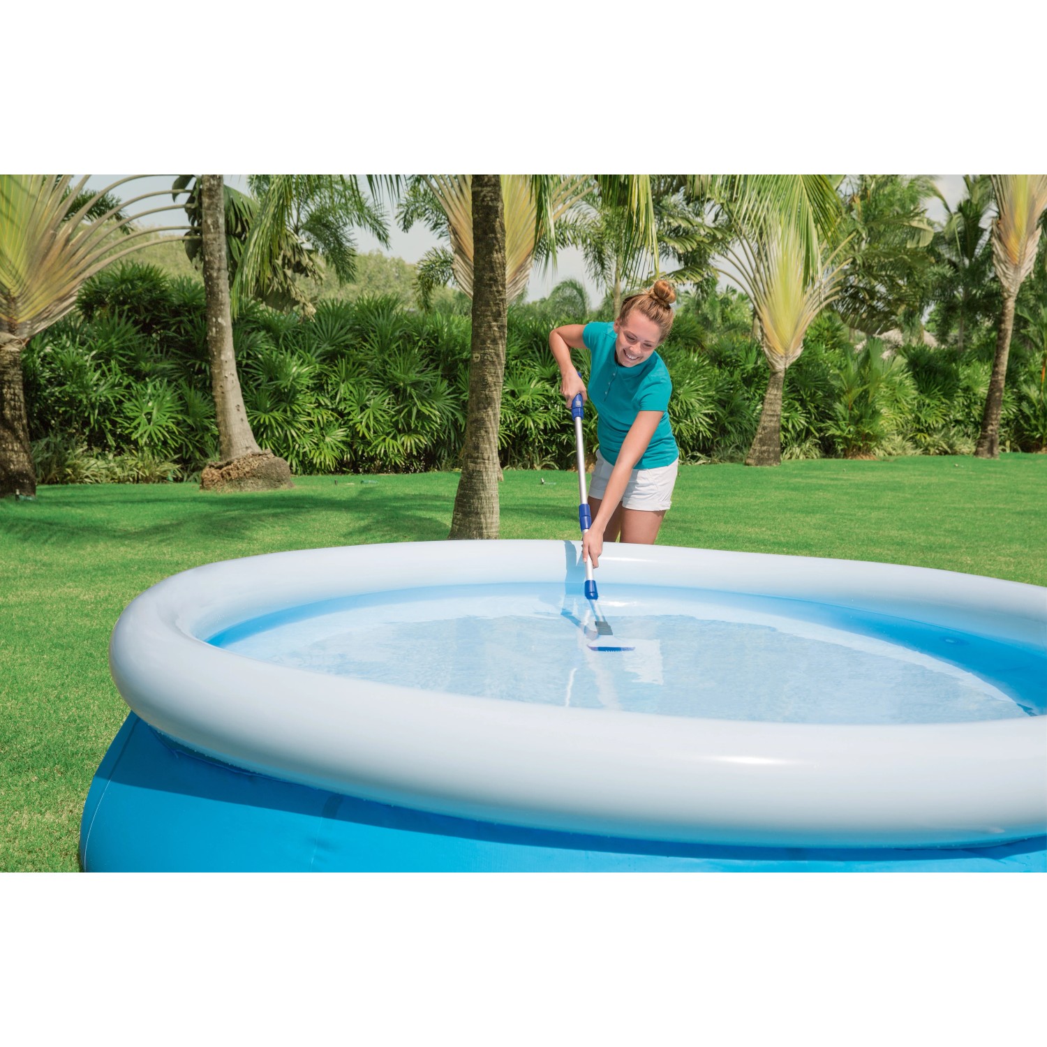 Donna pulisce la piscina con aspiratore. Pulizia piscina facilitata.