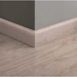 Battiscopa in legno chiaro fissato a parete e pavimento.