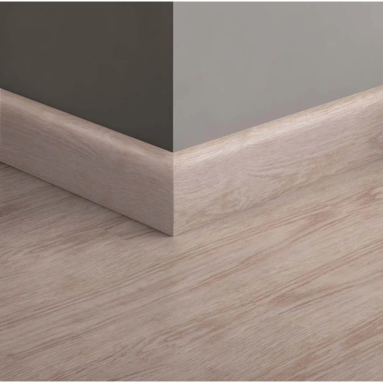 Battiscopa in legno chiaro fissato a parete e pavimento.