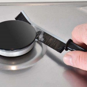 Spazzola per la pulizia dei fornelli in uso, utensile da cucina per piani cottura puliti.