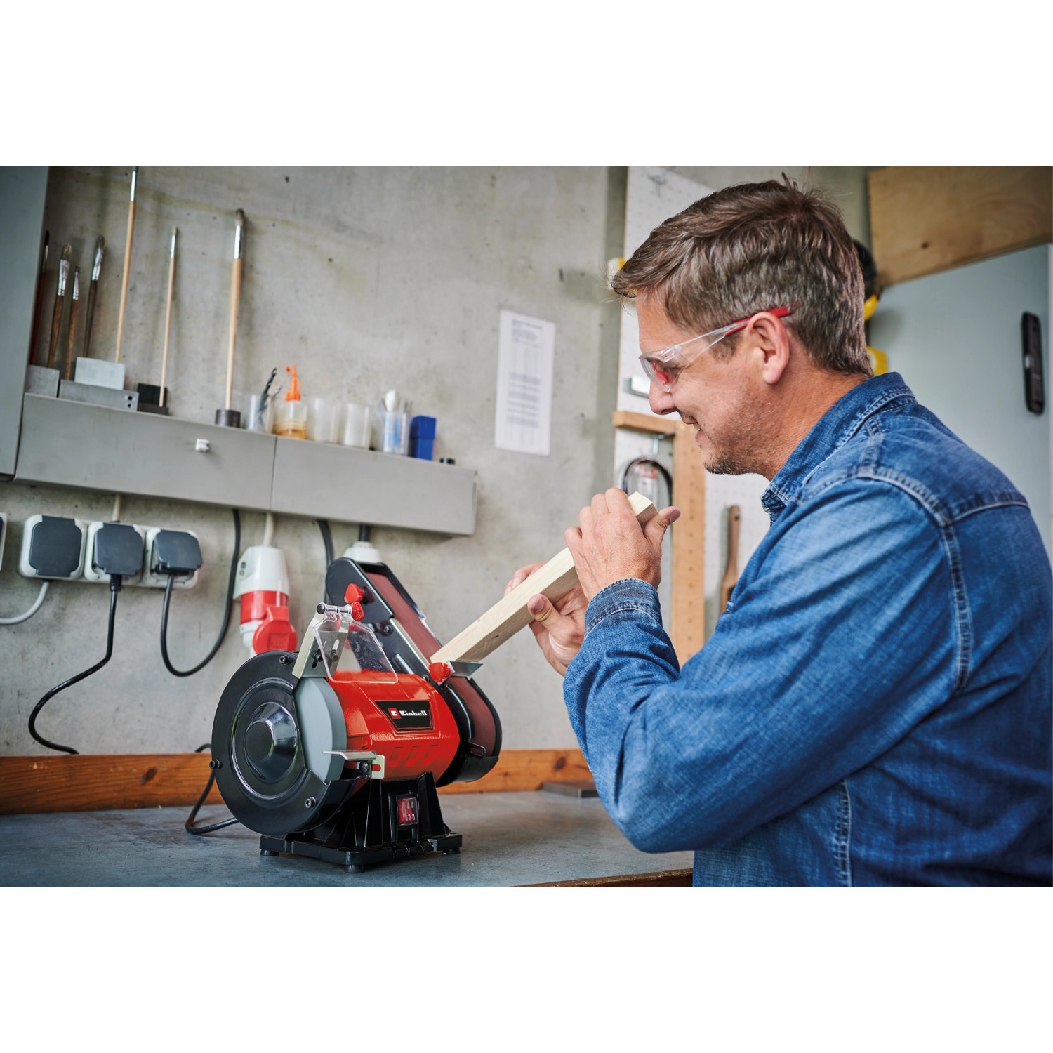 Smerigliatrice da banco Einhell TC-US 350 in uso con uomo e pezzo di legno.