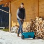 Donna che usa lo spargitore Gardena L per spargere materiale antigelo in inverno.