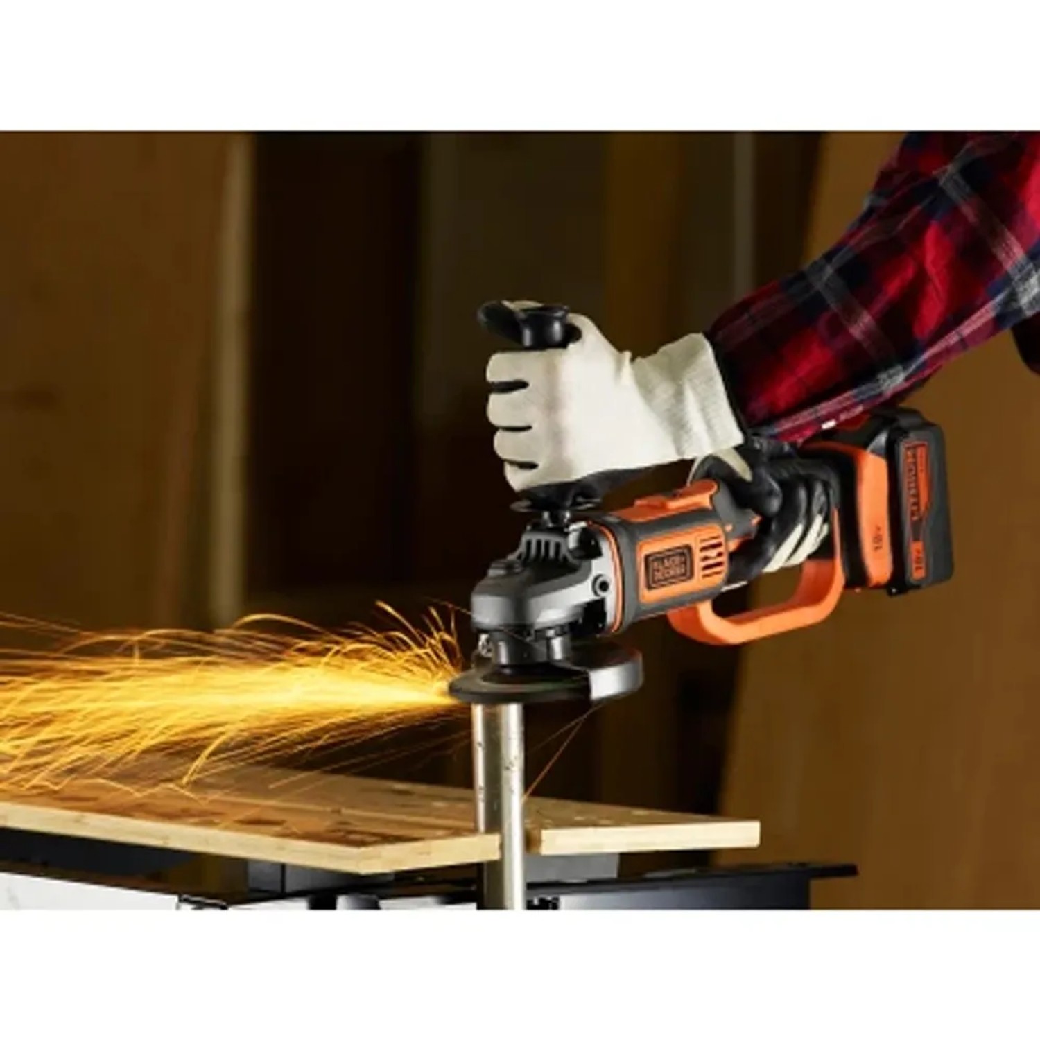 Smerigliatrice angolare a batteria Black+Decker BCG720M1 in uso, smerigliatura con scintille.
